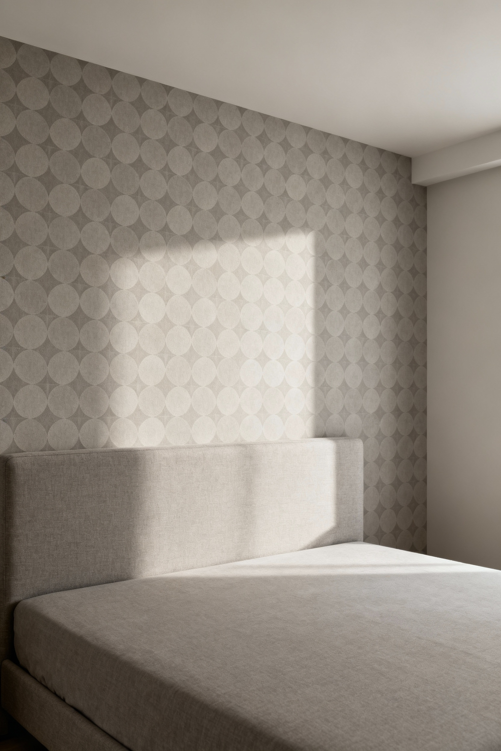 Modern bedroom with a serene greige geometric wallpaper featuring interlocking circles on the accent wall behind a bed, showcasing contemporary visual interest.