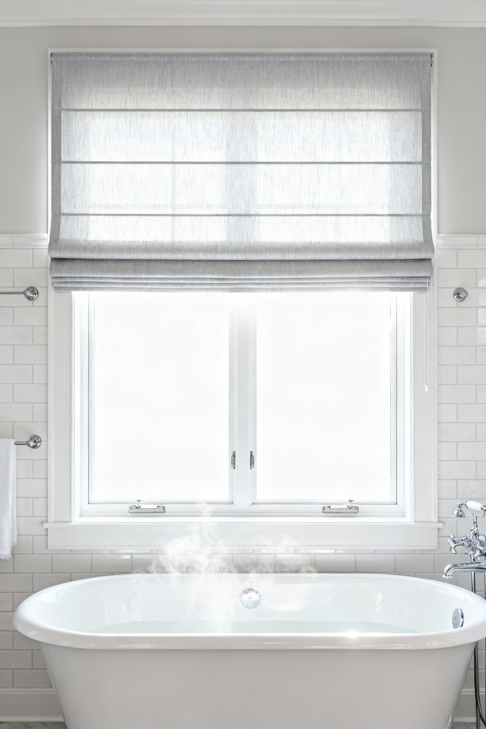 Full view of a bright, contemporary bathroom featuring a large white soaking tub and a window dressed in a moisture-resistant light gray polyester Roman shade, emphasizing hygienic window treatments for high humidity areas.